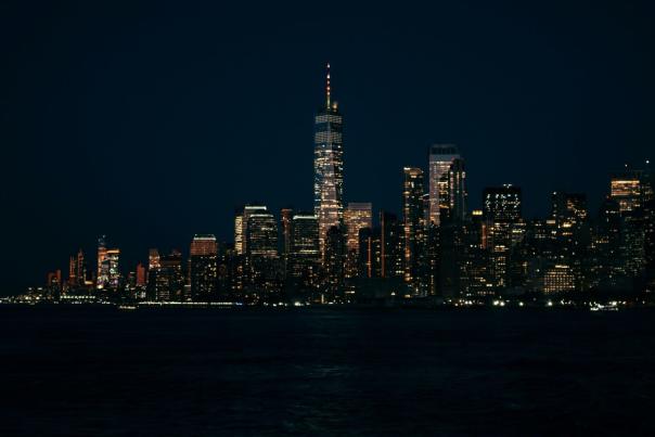 Lower Manhattan skyline illuminated at night as seen from the Staten Island Ferry crossing New York Harbor in winter