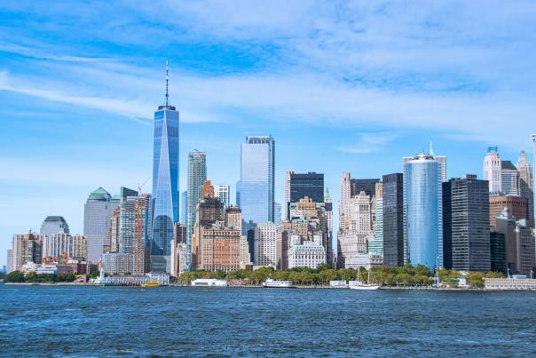 Lower Manhattan skyline with One World Trade Center seen across the water from a ferry deck on a clear day