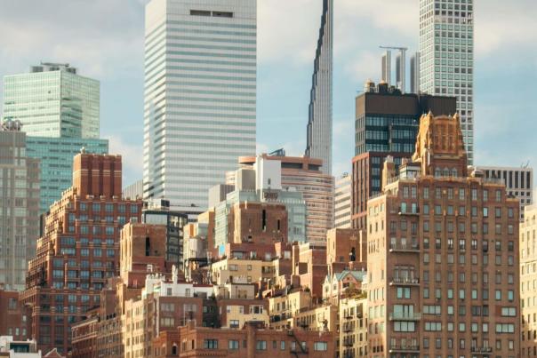 Dense Midtown Manhattan skyline featuring tall glass skyscrapers and mixed-era buildings, representing the city's architectural complexity and scale