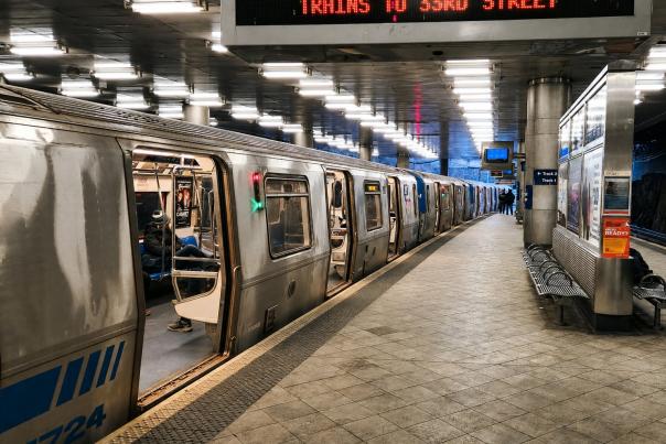 NJ Transit commuter train stopped at an underground station platform with illuminated signs directing passengers to 33rd Street in New York City.