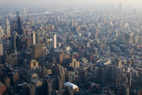 Aerial daytime view of dense New York City skyscrapers and the city grid stretching to the horizon