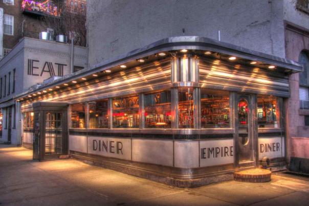 Exterior of the Empire Diner in Chelsea, Manhattan at night, a classic NYC sit-down dining setting where tipping is expected