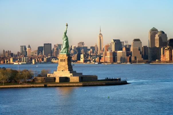 Aerial view of the Statue of Liberty on Liberty Island with the Manhattan skyline and Empire State Building in the background across New York Harbor