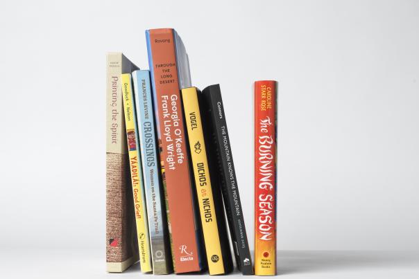 Stack of books by New Mexico authors featured in New Mexico Magazine's 2025 reading list.