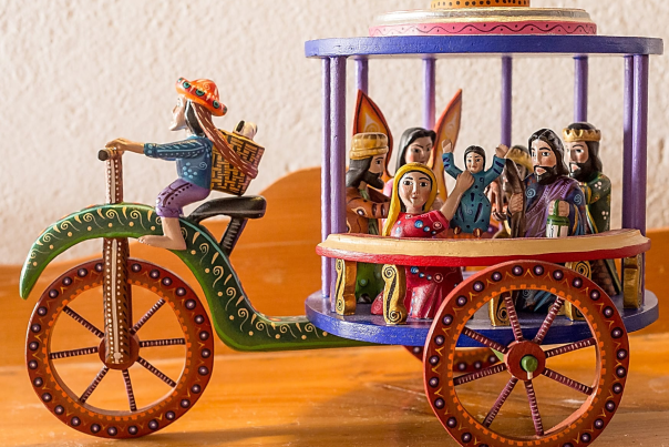 Colorful wooden nacimiento on a decorative tricycle.