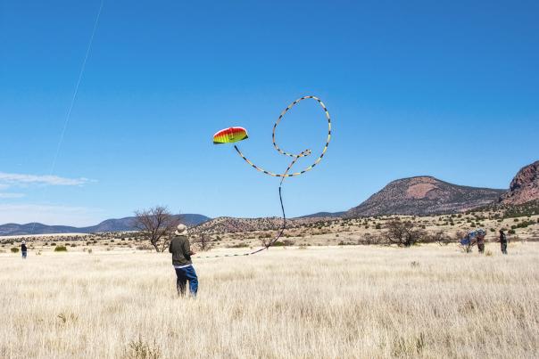 Kite flyer launches colorful kite at Whitewater Mesa Kite Flying Picnic near Glenwood.