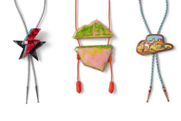 Three colorful contemporary bolo ties on display, including a star-shaped design, a layered pink and green bolo, and a bolo shaped like cowboy hat.