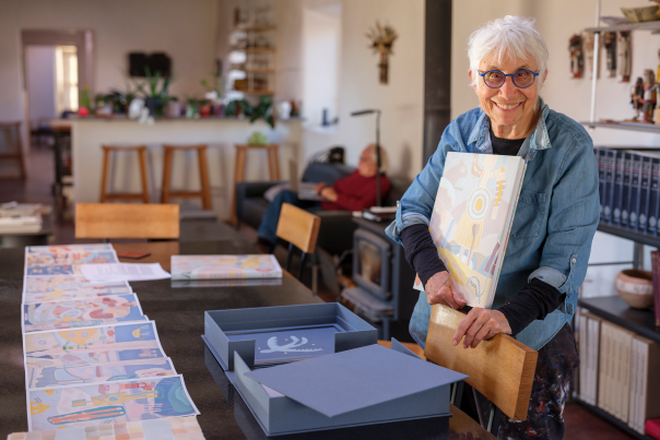 Judy Tuwaletstiwa reviewing pages from her book "Chaco Series"