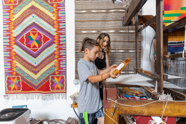 Felix Trujillo practices weaving techniques with Emily Trujillo (no relation) at Centinela Traditional Arts.