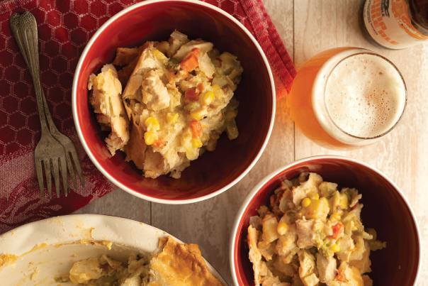 Two red bowls of green chile pot pie.