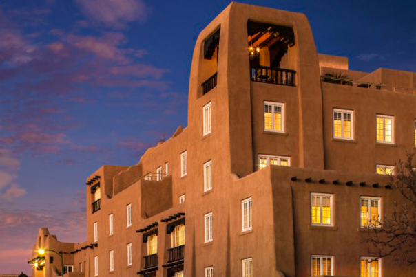 La Fonda on the Plaza, a historic Santa Fe hotel, illuminated at twilight.