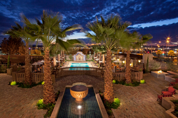 Palm-lined pool at Hotel Encanto de Las Cruces at night.