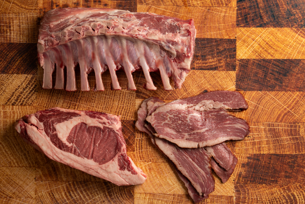 Close-up of premium raw meat cuts, including rib back and marbled steaks.