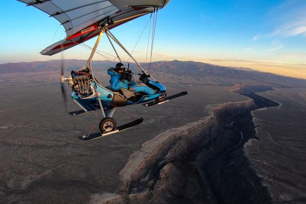 Chris Dahl-Bredine pilots his modified two-seat ultralight trike over the Río Grande Gorge, near Taos.