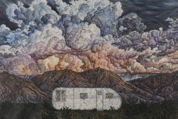 A silver trailer sits in front of a mountain range with dramatic, swirling clouds overhead.