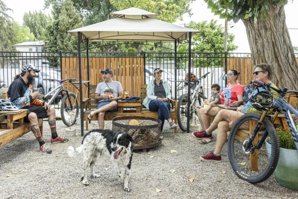A group of cyclists and a dog relax under a gazebo at Barefoot Bikes in Aztec, New Mexico.