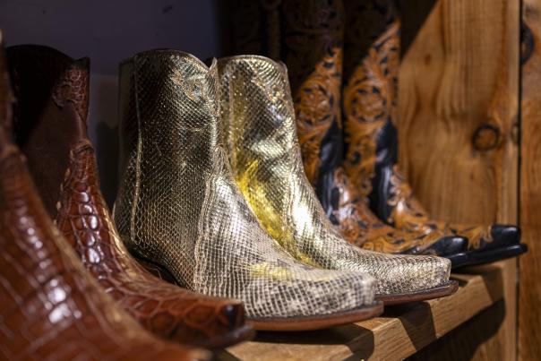 A close-up shot of snakeskin boots on a wooden shelf.
