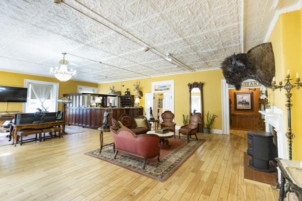 Elegant sitting room at the St. James Hotel with yellow walls, antique furniture, and tin ceilings.