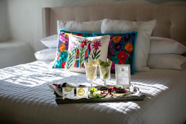 A softly lit bedroom at Hacienda de Las Cruces featuring a large bed with white linens.