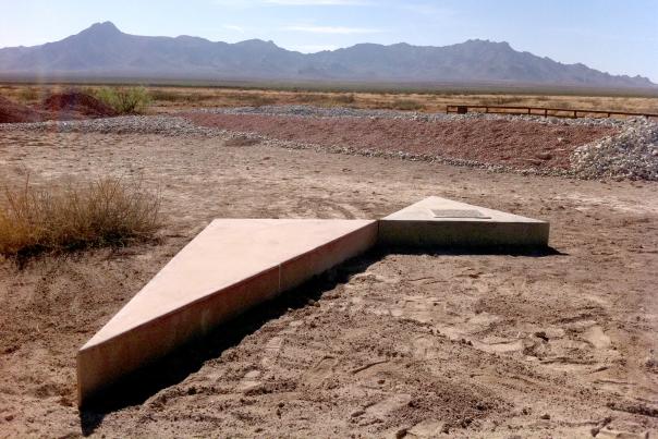 Concrete triangular slabs forming the Deming Triangles installation in the New Mexico desert.
