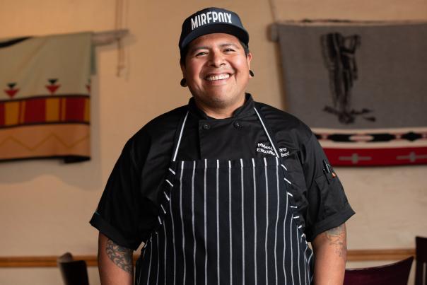 Chef Myles Lucero standing in the Prairie Star kitchen, wearing his chef coat.