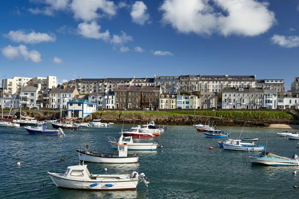 Boats docked at Portrush Harbour with Kerr Street and the RNLI Portrush Lifeboat Station visible in the background.