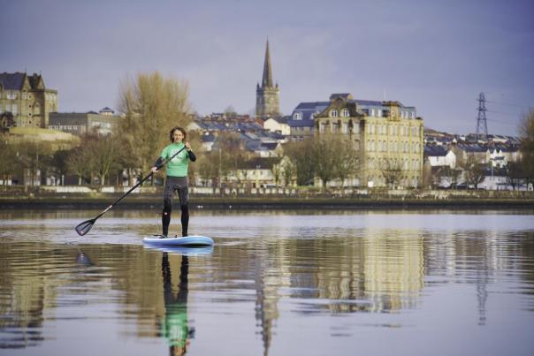 Man standing on a paddle board on Lough Foyle, County Londonderry.