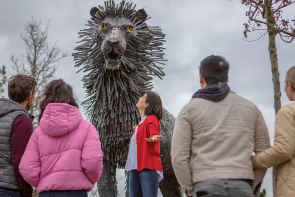A group in front of a statue of a lion 'Aslan' from the C.S. Lewis Square