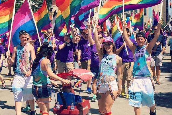 A group of young people holding rainbow flags in the Cincinnati Pride parade