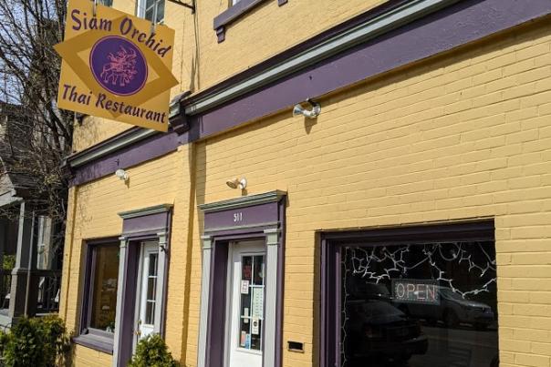 exterior shot of yellow buildling with purple trim and business sign of siam orchid restaurant on historic fairfield avenue in bellevue kentucky