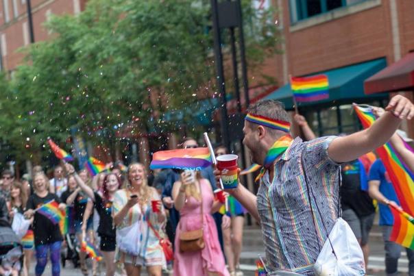 A crowd holding rainbow flags at the Cincinnati Pride Parade