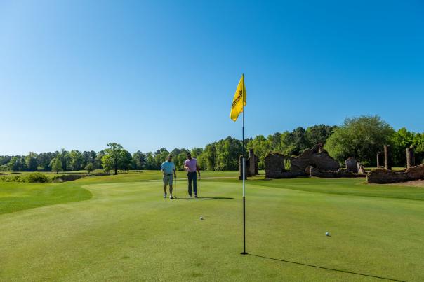 two golfers on the green on a beautiful sunny day