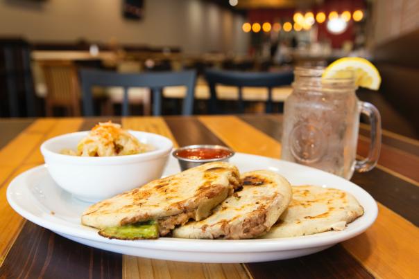 Pupusas at a restaurant served in a plate with salsa