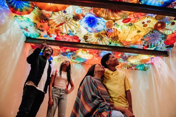 Family of 4 looking at a ceiling of Chihuly glass at the Oklahoma City Museum of Art