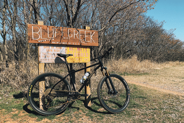 A mountain bike in front of the Bluff Creek sign
