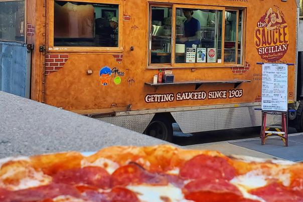 View of the Saucee Sicilian food truck with a pizza in the foreground in OKC