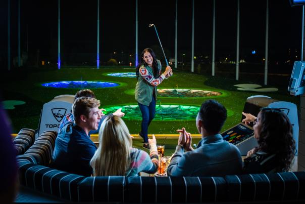 Topgolf group playing golf at night