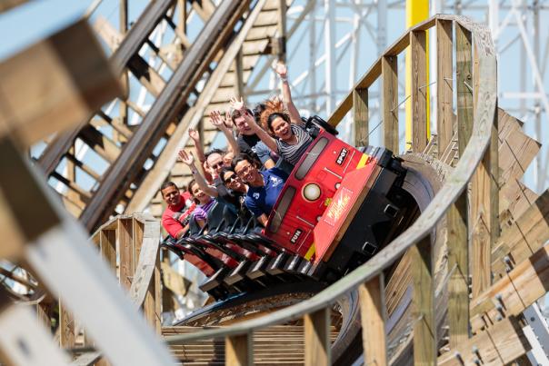 Guests riding the White Lightning coaster with their arms in the air at Fun Spot America in Orlando, Florida.