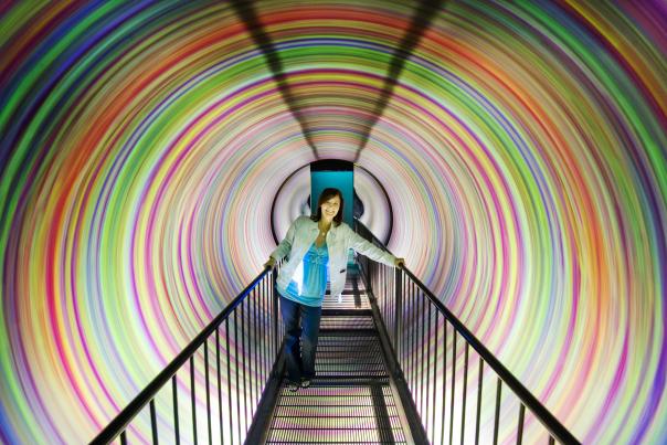 A woman makes her way through the colorful spiraling tunnel at WonderWorks.