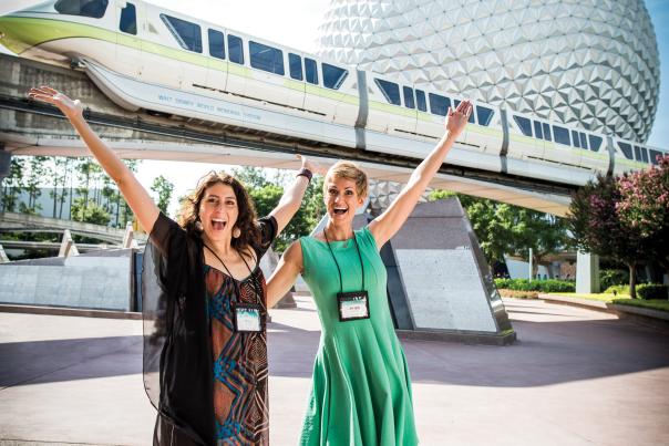 Two women in front of the monorail and Spaceship Earth at Epcot