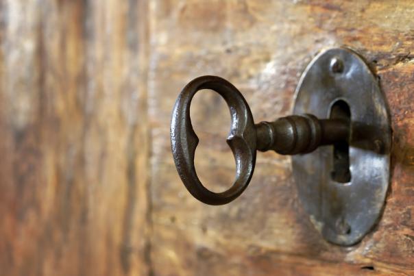 Closeup of an old keyhole with key on a wooden antique door