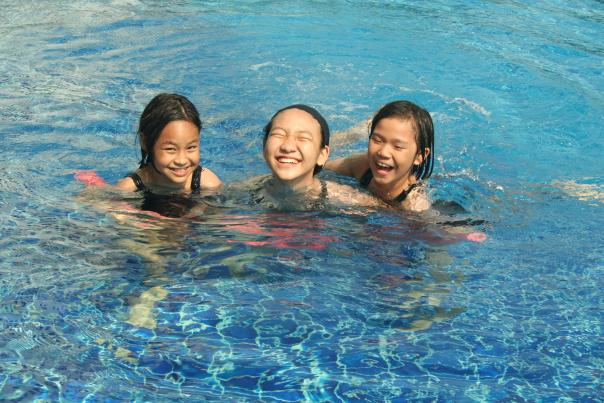 three asian children in a swimming pool