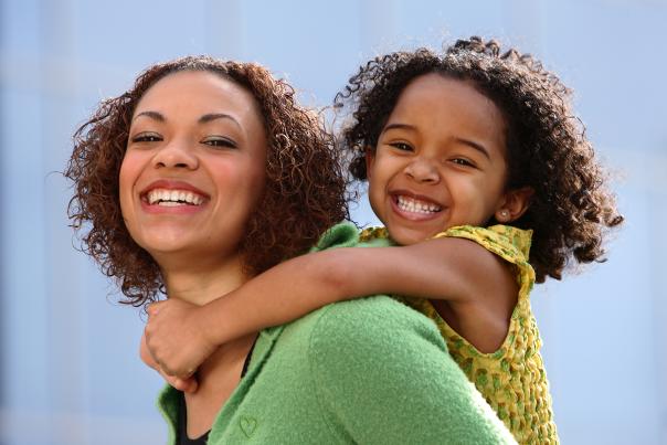 An African-American mother and daughter smiling