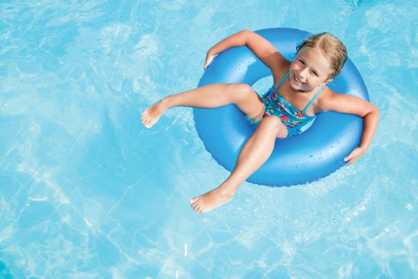 a girl floating on an inner tube in a swimming pool