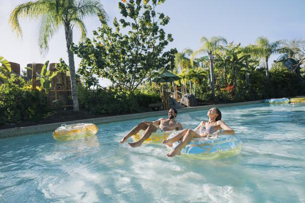 A couple floating in inner tubes on a lazy river in Universal's Volcano Bay.