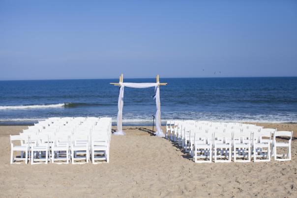 Chairs and an arbor set up for a wedding ceremony on the beach in the Outer Banks