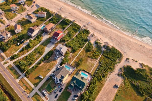 An aerial shot of beach-front rental homes situated on the coast of the Outer Banks in North Carolina.