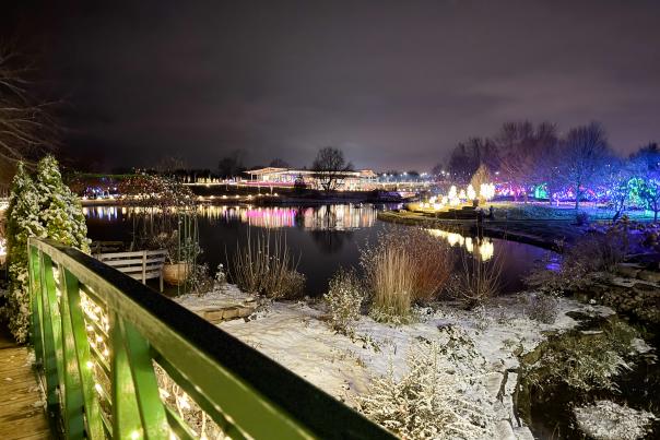 Wide angle shot of the pond, Monet bridge, and Longhouse Visitors' Center at the Overland Park Arboretum & Botanical Gardens during the 25th Annual Luminary Walk