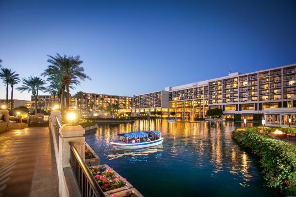A boat in the water at dusk at JW Marriott Desert Springs Resort with the resort in the background.