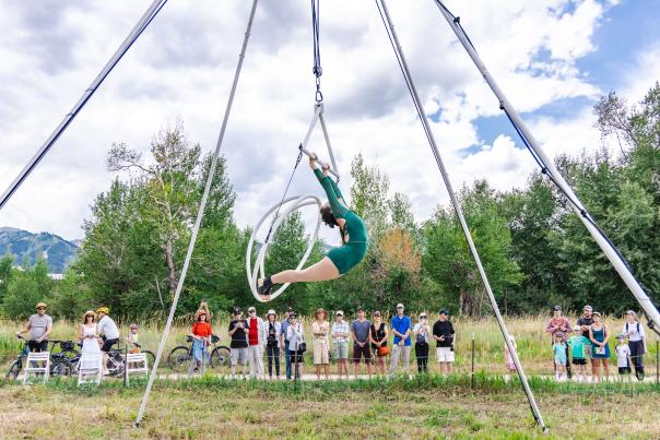 An aerialist performs along a trail with a small crowd in Park City, UT